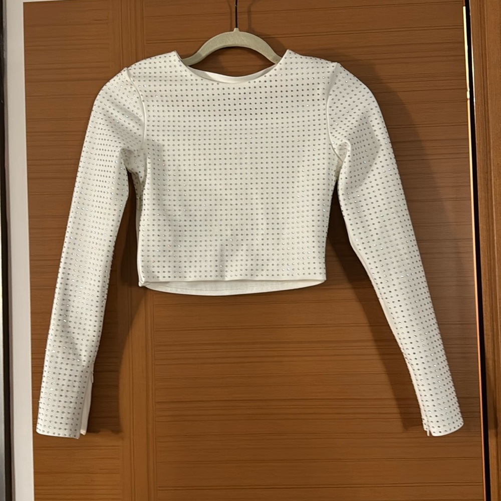 New Maniere De Voir white bedazzled long sleeve shirt with a side slit. Size 2